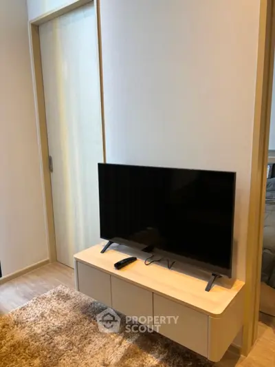 Modern living room with sleek TV stand and cozy carpet flooring