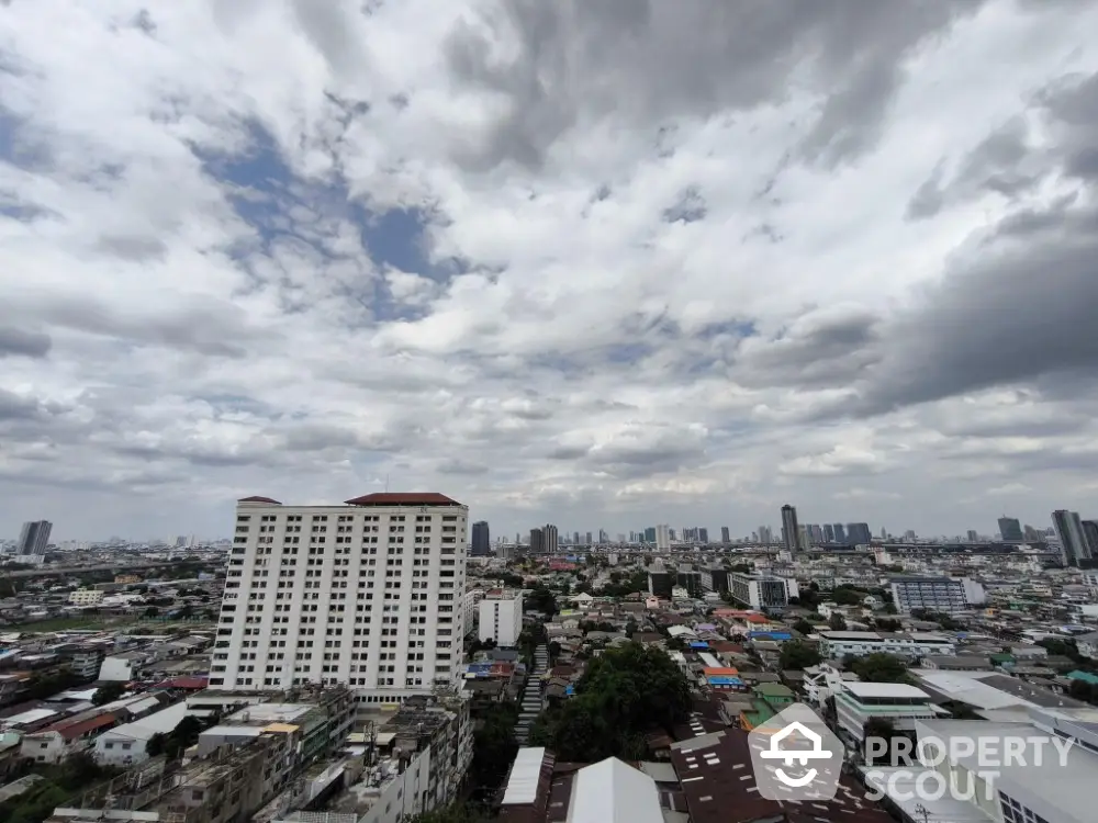 Stunning cityscape view from high-rise building showcasing urban skyline under dramatic cloudy sky.