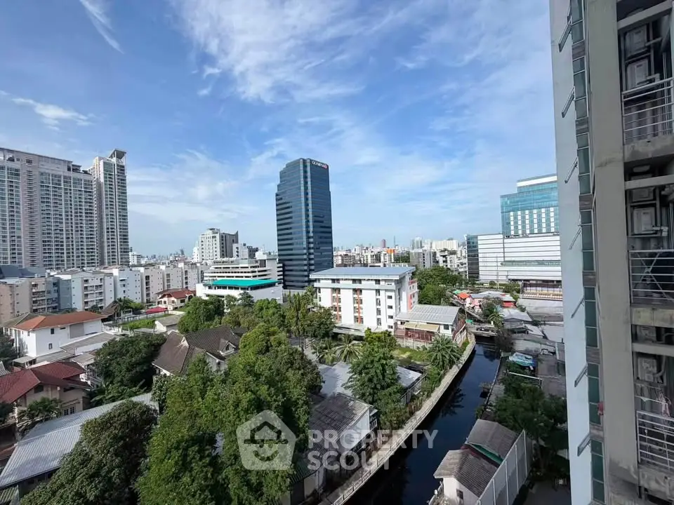 Stunning cityscape view from high-rise building with lush greenery and modern architecture.