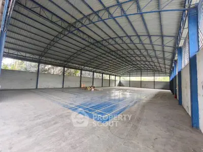 Spacious indoor sports facility with high ceiling and ample natural light
