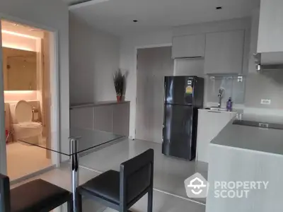 Modern kitchen with sleek gray cabinetry and stainless steel appliances, featuring an open layout that seamlessly connects to the dining area.