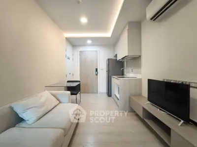 Modern living room with sleek furniture and integrated kitchen appliances.