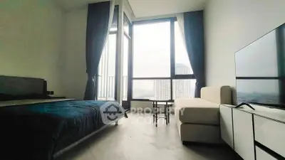 Modern bedroom with large windows and city view, featuring a cozy bed and stylish sofa.