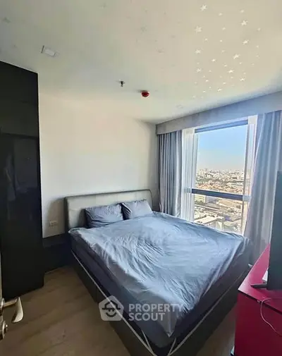 Modern bedroom with city view, featuring stylish decor and ample natural light.