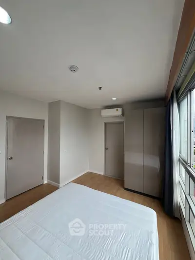 Spacious bedroom with modern wardrobe and large window view