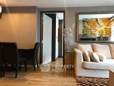 Stylish living room with cozy sofa and elegant dining area, featuring modern decor and warm lighting.