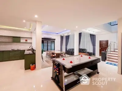 Spacious open-plan living area with modern kitchen and air hockey table