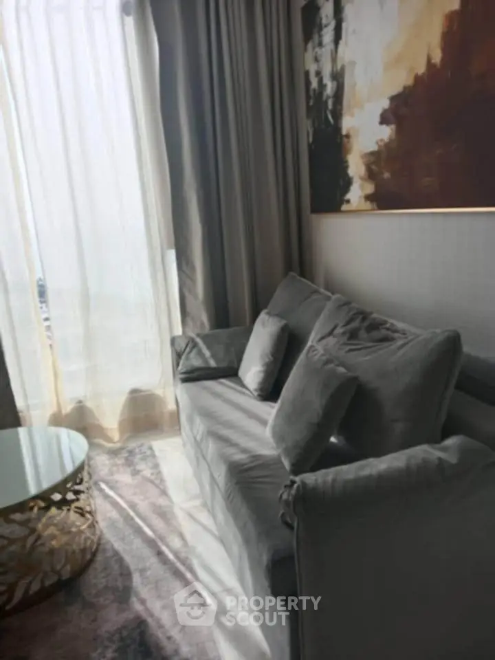 Stylish living room with modern gray sofa and abstract art, perfect for cozy relaxation.