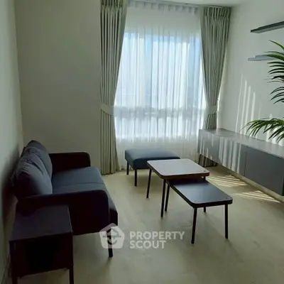 Modern living room with sleek furniture and large window for natural light.