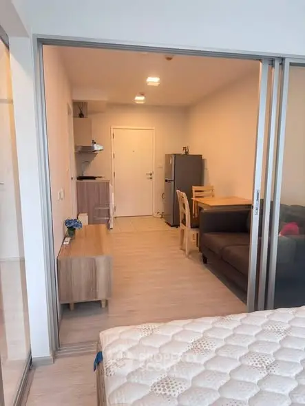 Modern studio apartment with open layout, featuring cozy living area and compact kitchen.