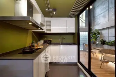 Modern kitchen with sleek design and open layout next to stylish balcony.