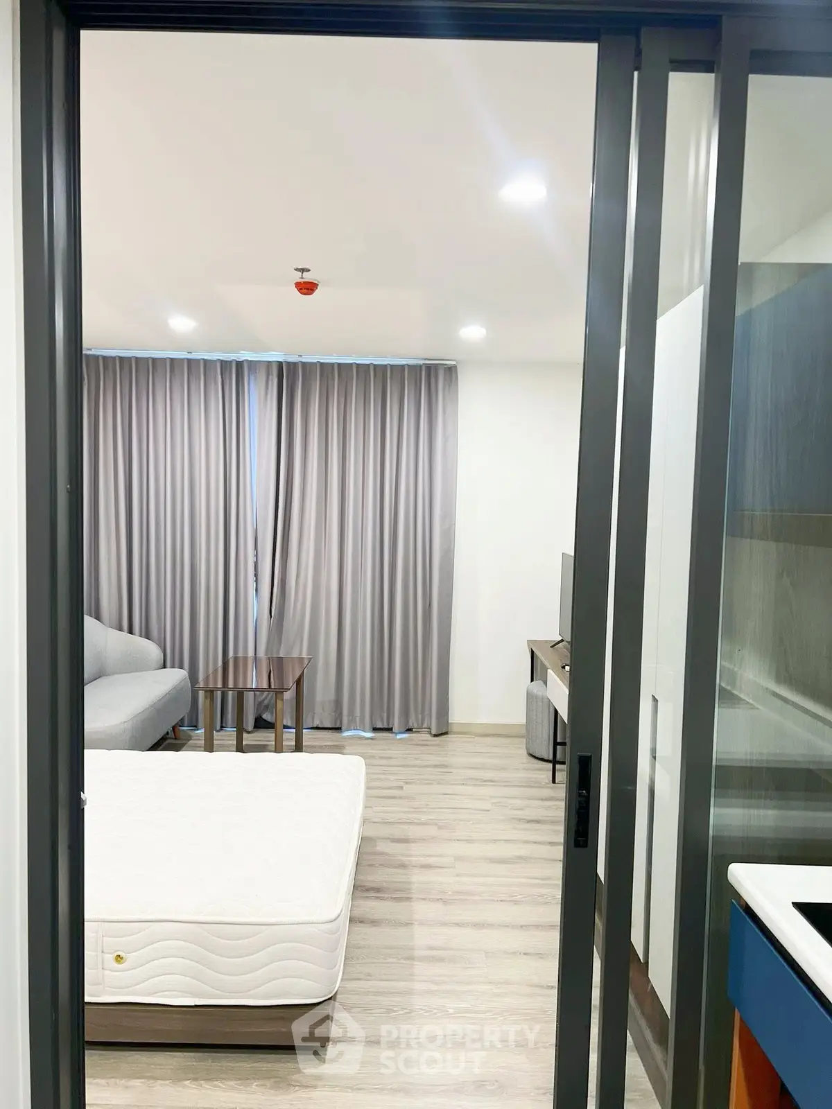 Modern apartment interior with sliding doors, cozy living area, and natural light.