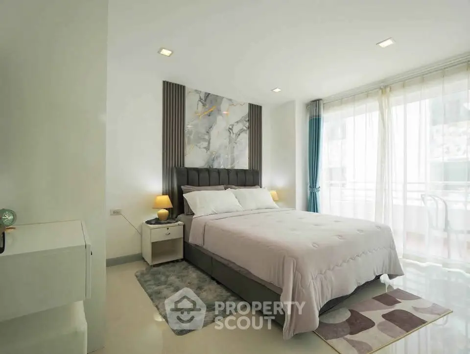 Modern bedroom with elegant decor and large windows for natural light