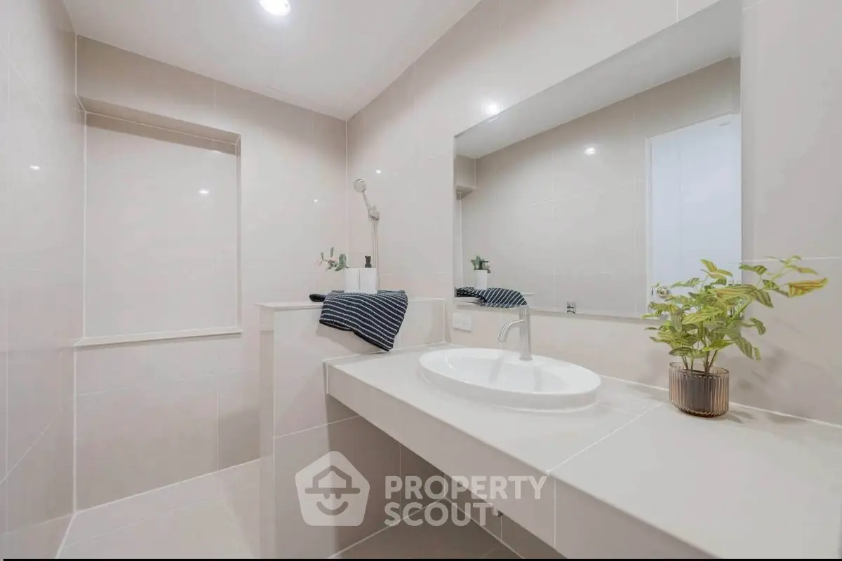 Modern bathroom with sleek design and elegant fixtures, featuring a spacious vanity and stylish decor.