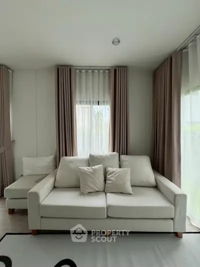 Elegant living room with modern white sofa and chic curtains, perfect for cozy relaxation.