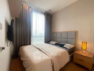 Cozy bedroom with large window and modern decor in a stylish apartment.