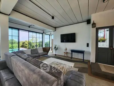 Spacious living room with modern decor and large windows offering scenic views.