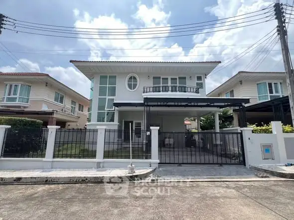 Modern two-story house with gated driveway and spacious front yard in suburban neighborhood.