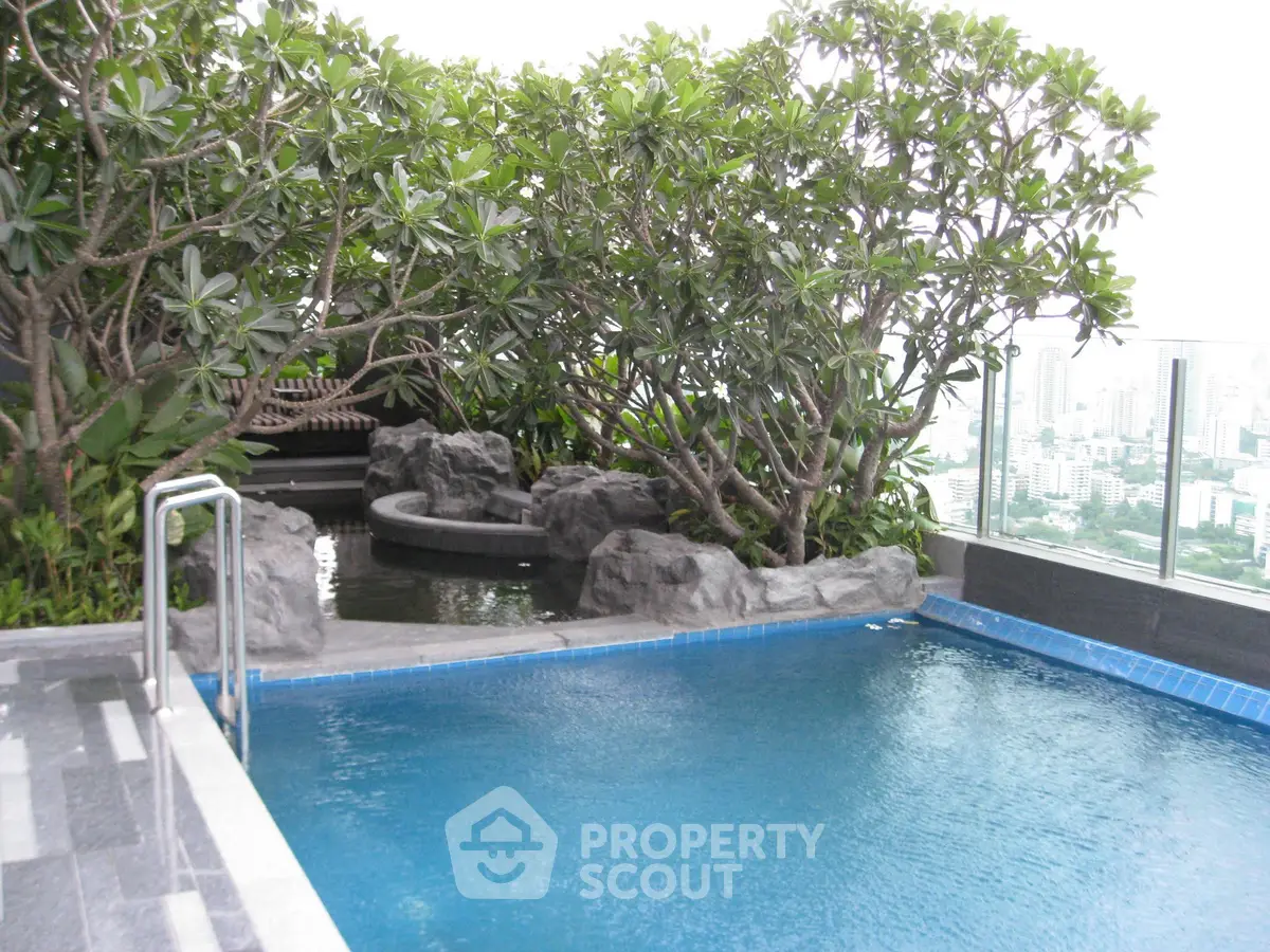 Luxurious rooftop pool with lush greenery and stunning city views, perfect for relaxation and leisure.