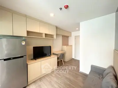 Modern living room with sleek cabinetry and cozy seating in a stylish apartment.