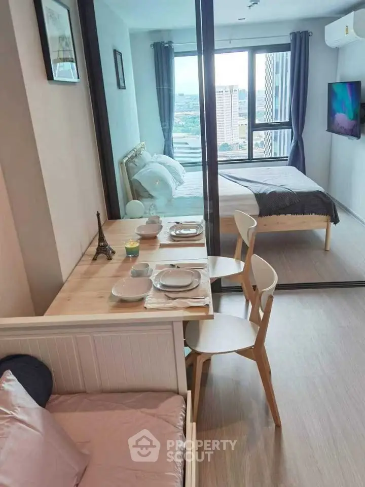 Modern studio apartment with cozy dining area and stylish bedroom view.