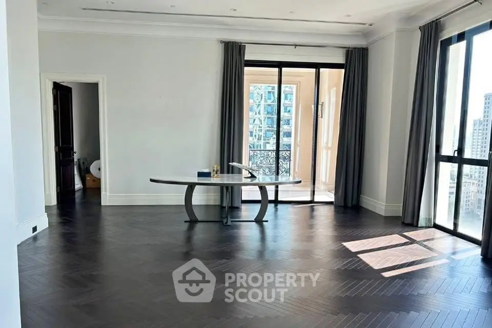 Spacious modern living room with elegant flooring and large windows offering city views.