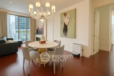 Elegant dining area with modern chandelier and artwork in a stylish apartment.