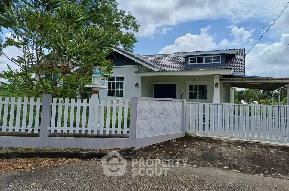 Charming single-story house with a spacious yard and modern fence, perfect for family living.
