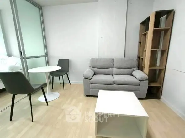 Modern living room with cozy sofa, table, and chairs in minimalist design.