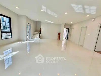 Spacious modern living room with glossy tiled floors and ample natural light