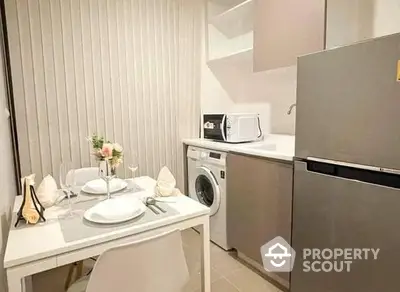 Compact modern kitchen with integrated appliances and a cozy dining area, perfect for urban living and entertaining guests.