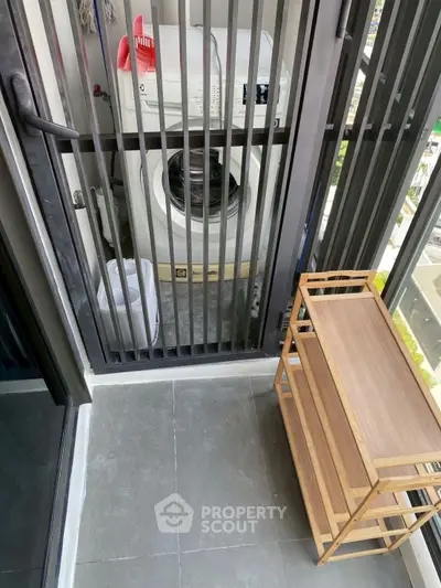 Compact balcony with washing machine and wooden shelf, ideal for urban living.