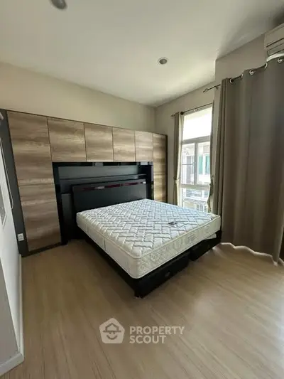 Spacious bedroom with large window and modern wardrobe