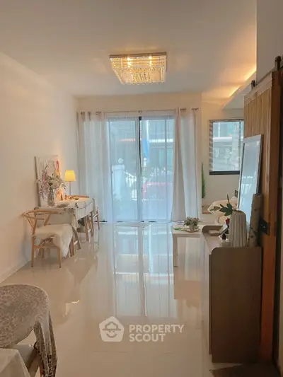 Elegant living room with glossy floors and chic decor, featuring a large window for natural light.