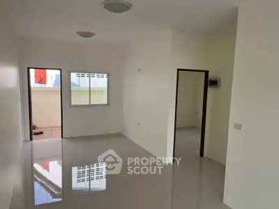 Spacious unfurnished living room with glossy tiled floors and natural light.