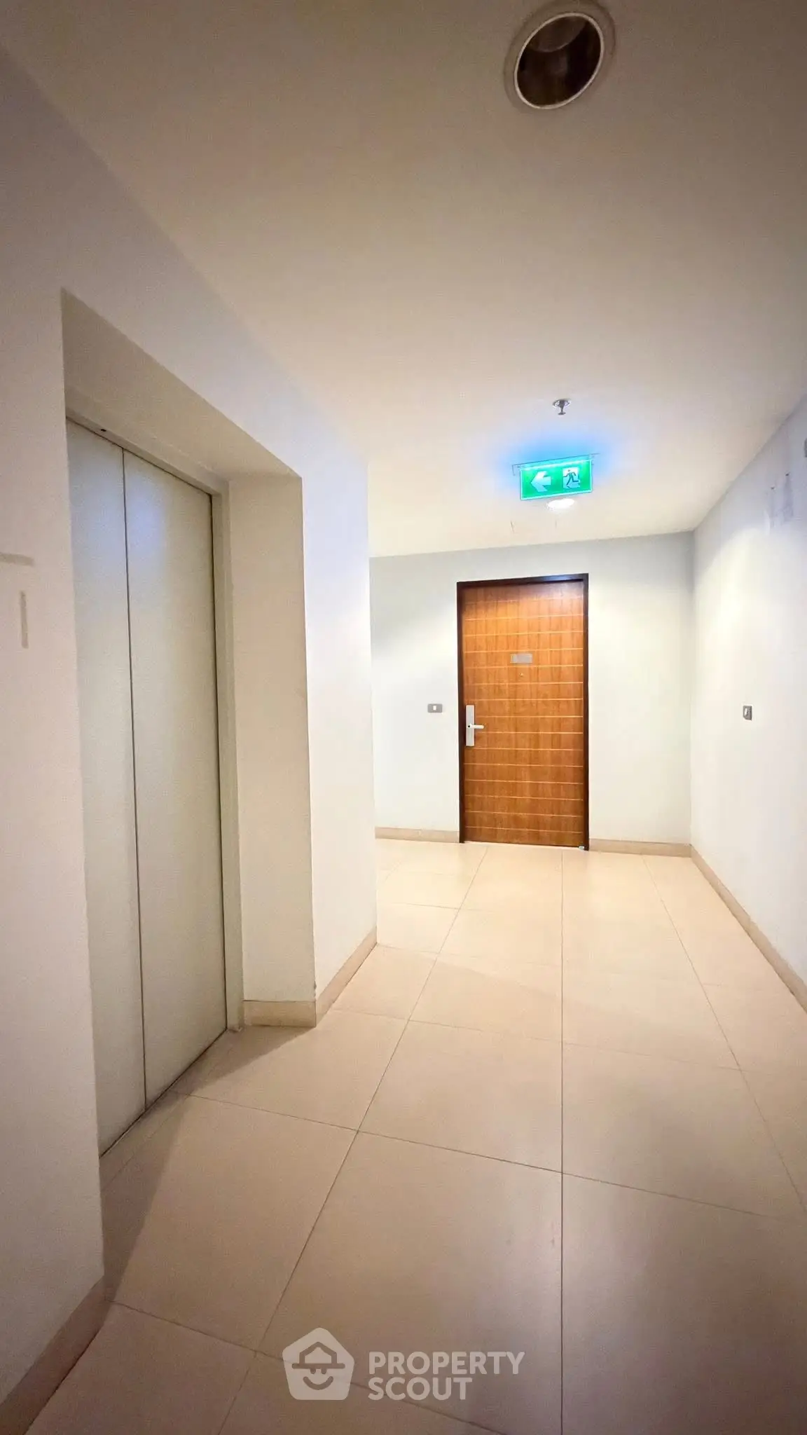 Modern apartment corridor with elevator and wooden door entrance