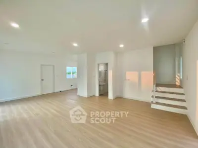 Spacious open-plan living area with modern wooden flooring and ample natural light.
