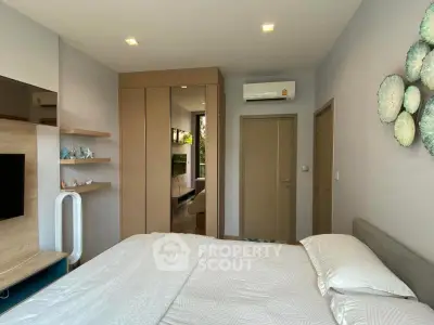 Modern bedroom with sleek design, featuring built-in wardrobe and air conditioning unit.