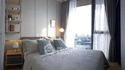 Cozy modern bedroom with large window offering stunning city view, elegant decor, and ample natural light.