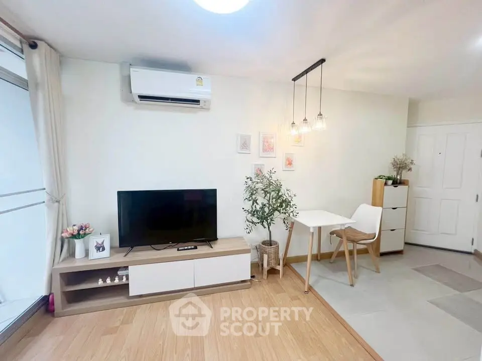 Modern living room with stylish decor, TV unit, and dining area in a cozy apartment.