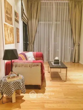 Cozy living room with stylish decor and large window drapes, perfect for relaxation.
