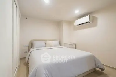 Cozy bedroom with modern air conditioning and minimalist decor, perfect for relaxation.