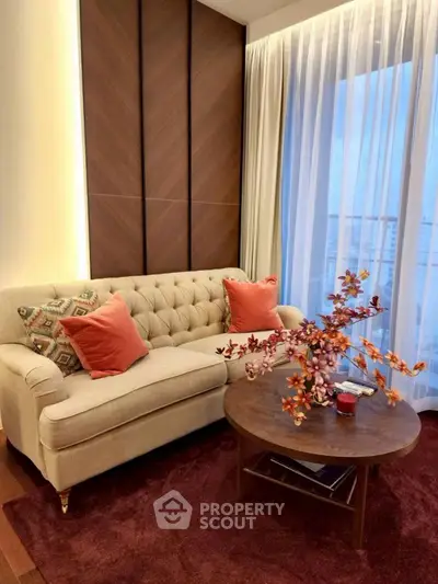 Elegant living room with plush sofa, stylish decor, and large window view.