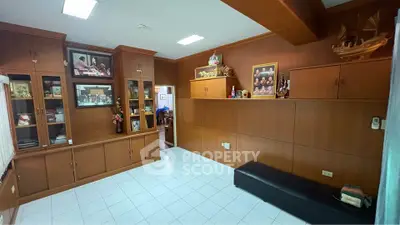 Spacious room with wooden cabinets and white tiled floor, perfect for storage or study area.