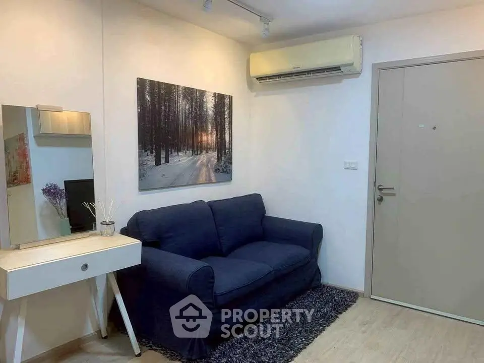 Cozy living room with blue sofa, wall art, and air conditioning in modern apartment.