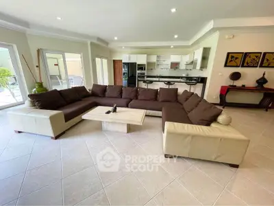 Spacious living room with modern L-shaped sofa and open kitchen layout