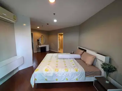 Spacious bedroom with modern decor and ensuite bathroom in a stylish apartment.