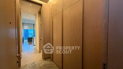 Luxurious apartment hallway leading to a spacious living room with city view.