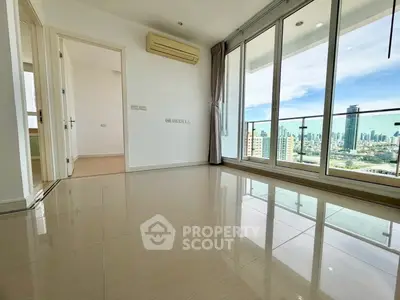 Spacious modern living room with city view and large windows in high-rise apartment.