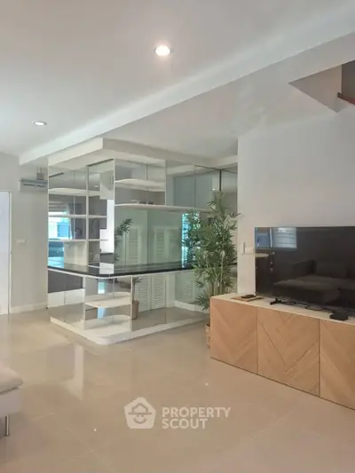 Spacious modern living room with sleek design and open layout, featuring stylish furniture and ample natural light.